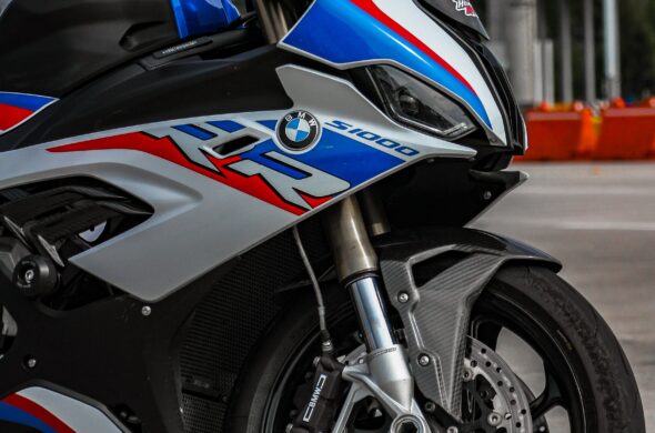 The front wheel of a red, blue and silver BMW S 1000 RR Photo by Juan Sandoval Pacheco from Pexels