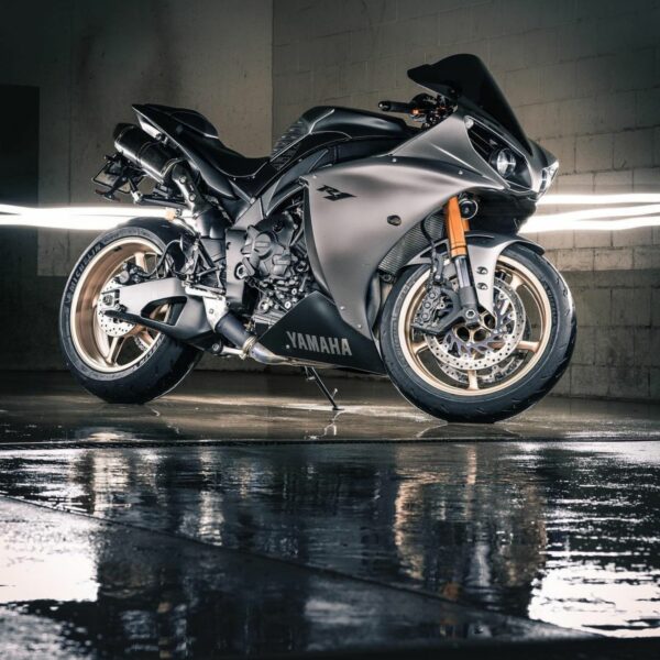A silver Yamaha YZF-R1 is reflected in the wet floor below Photo by Abhinav Toppo from Pexels