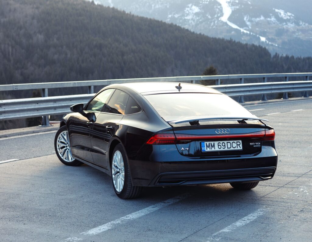 An Audi A-7 parked on a bridge overlooking a forest.
Photo by Balaci Media from Pexels