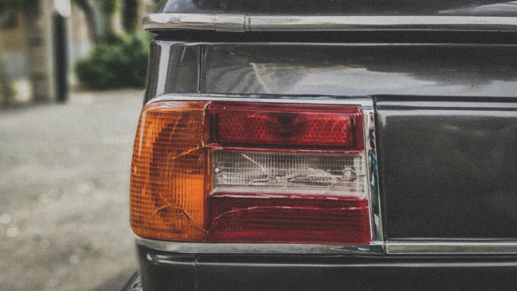 A cracked tail light on a black car.
Photo by Payam Tahery from Unsplash.