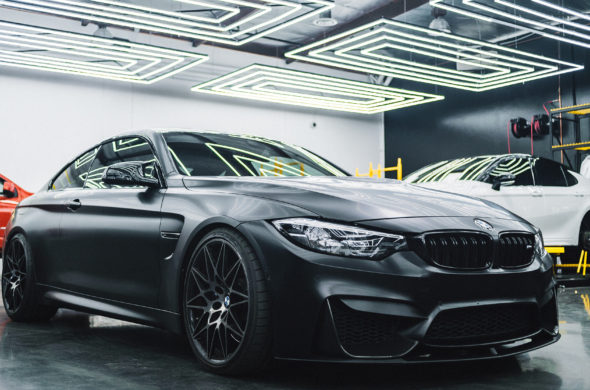 BMW sits in a garage alongside other cars
