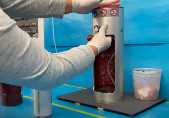 A person wearing white gloves working on a tubular machine
