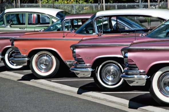 Display of vintage cars, colors pink, orange, green.