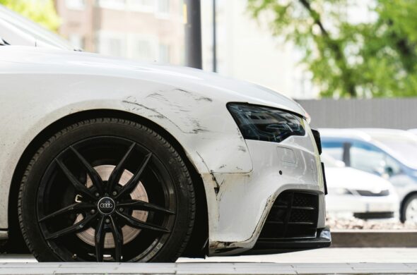 The front of a badly scratched white car Photo by Volodymyr Dobrovolskyy from Unsplash