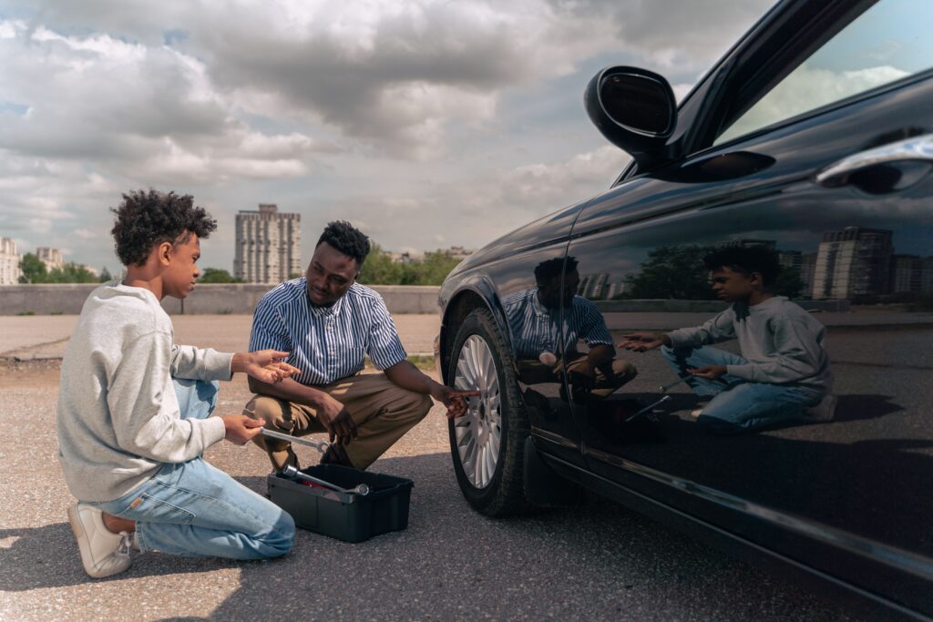 A father teaches his son how to fix a car. Photo by Ron Lach from Pexels