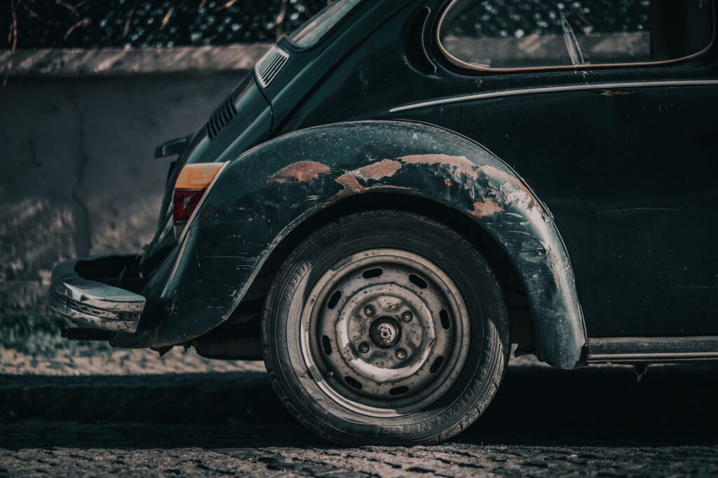 The back of a weathered green Volkswagen covered in many different types of scratches Photo by Tahir Osman from Pexels