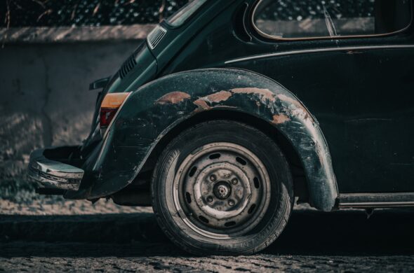 The back of a weathered green Volkswagen covered in many different types of scratches Photo by Tahir Osman from Pexels