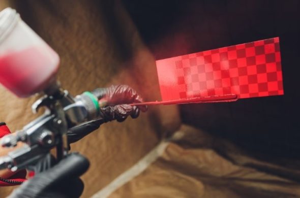 A person painting a racing flag red