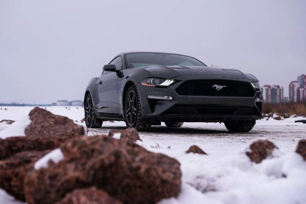 A black Mustang parked in the snow.
Photo by Vitali Adutskevich from Unsplash