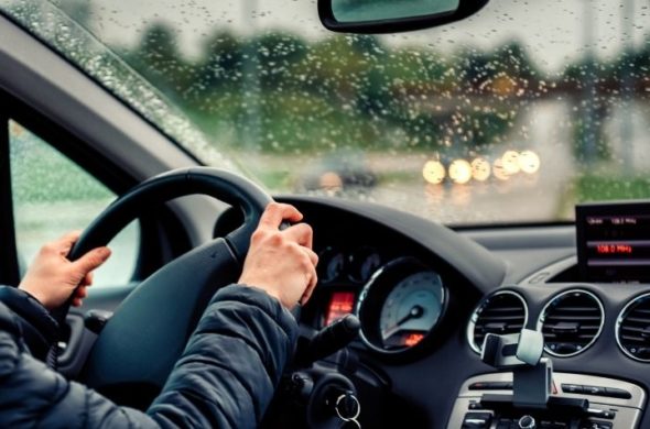A person driving a car on a rainy day
