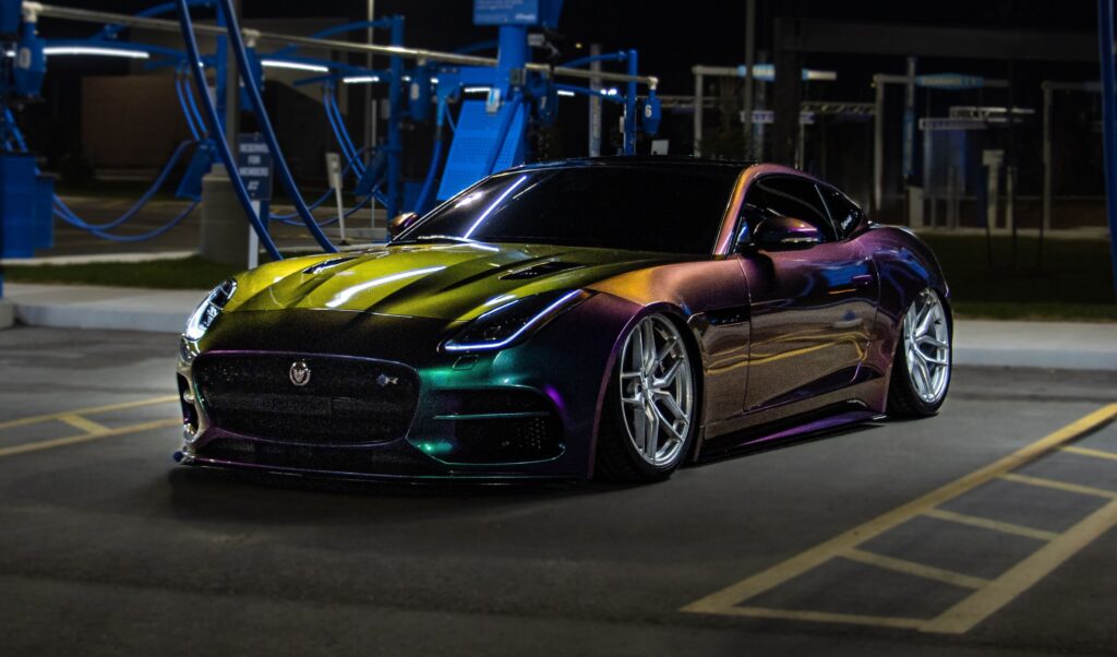 A vibrant sports car with multicolor finish in a well-lit urban area by night.
Photo by FramesnFuel from Pexels