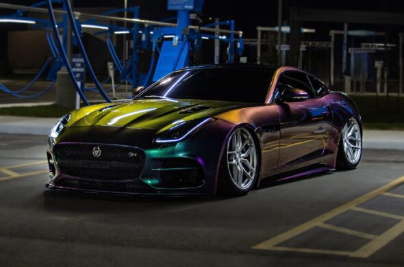 A vibrant sports car with multicolor finish in a well-lit urban area by night. Photo by FramesnFuel from Pexels